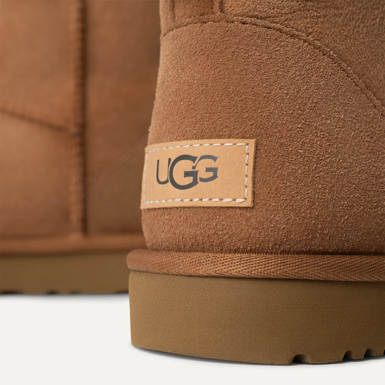 Close-up of brown UGG boots with a visible brand label. UGG Women's Classic Cozy Sheepskin Mini II Boot