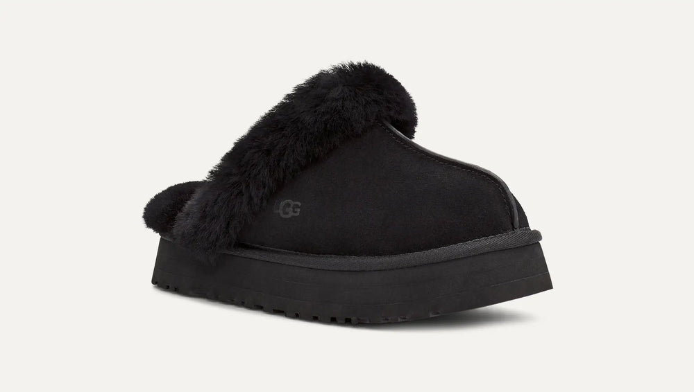 Black UGG slipper with fur trim on a white background. UGG Womens Disquette Cozy and Stylish Slippers