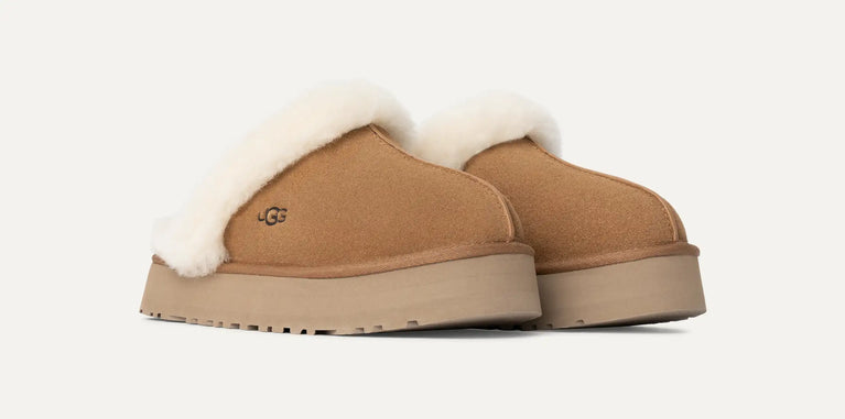 Pair of tan UGG slippers with white fur lining in volonka store. UGG Womens Disquette Cozy and Stylish Slippers