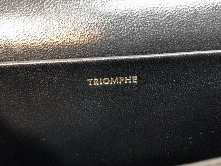 Black leather surface with 'TRIOMPHE' branding