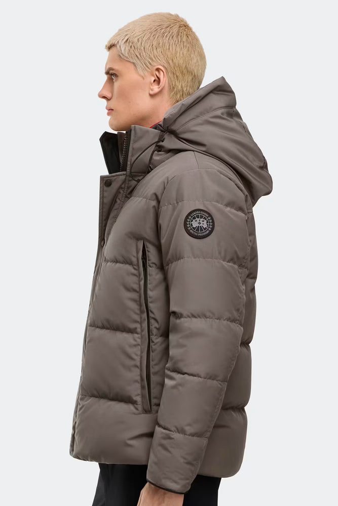 Man wearing a gray puffer jacket with a brand logo, Canada Goose Wyndham Parka Goose Men's Winter Jacket at Volonka.