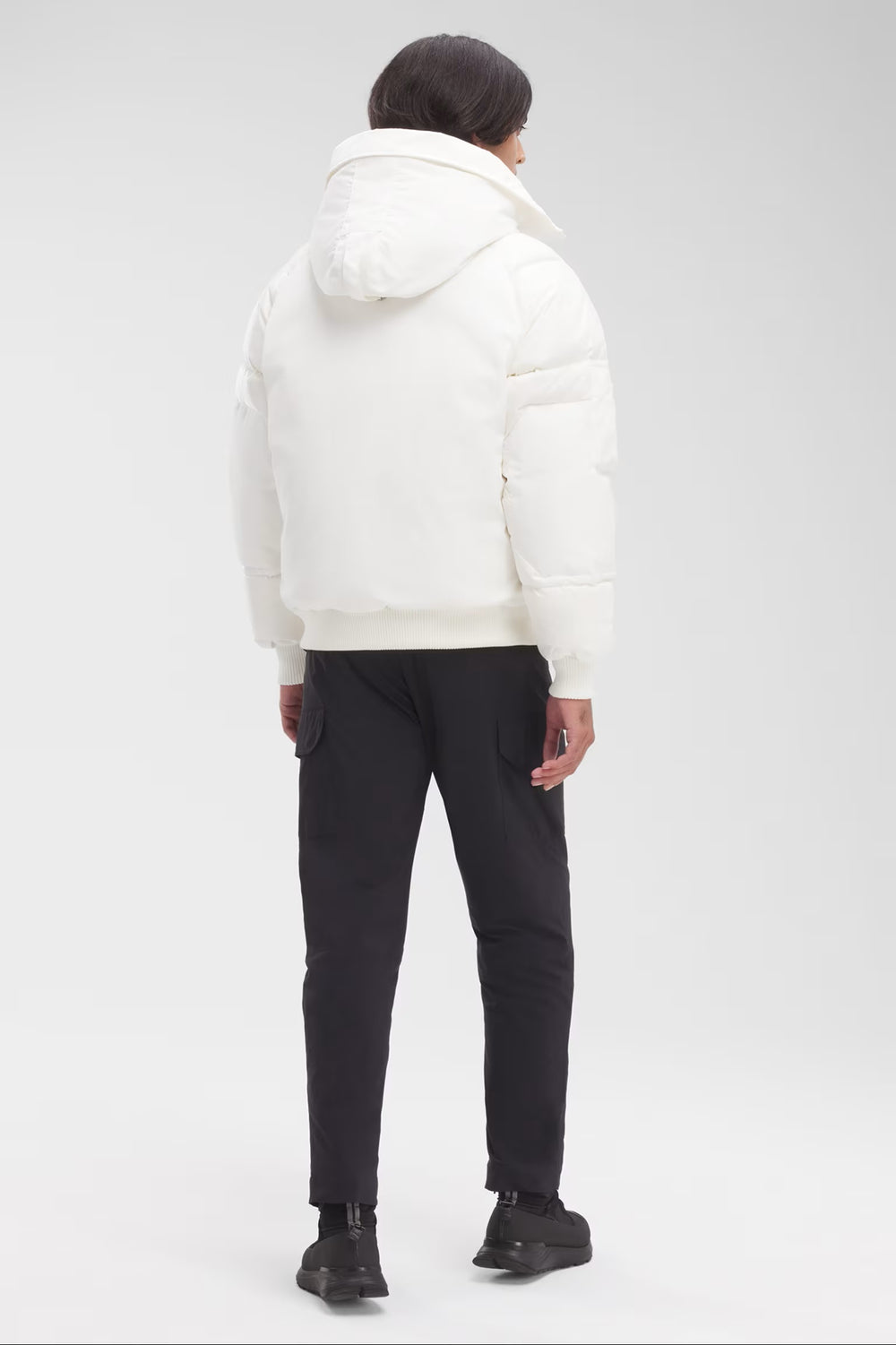 Man wearing a white puffer jacket and black pants, Canada Goose Paradigm Chilliwack Bomber Unisex Down Jacket at Volonka store.