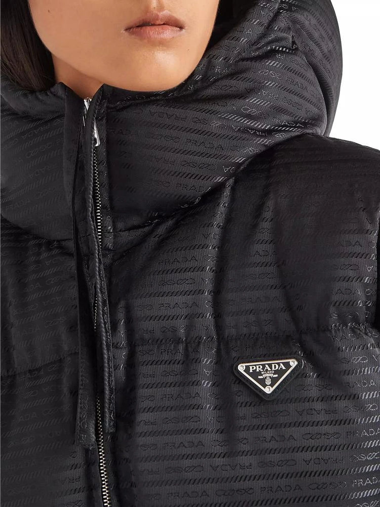 Close-up of a black Prada jacket with a logo on the chest.