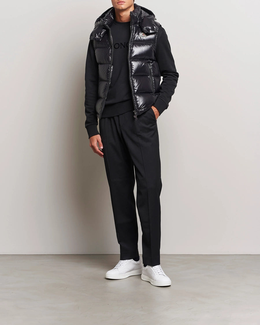 Man wearing a black outfit with a shiny vest. Moncler unisex Bormes down vest jacket