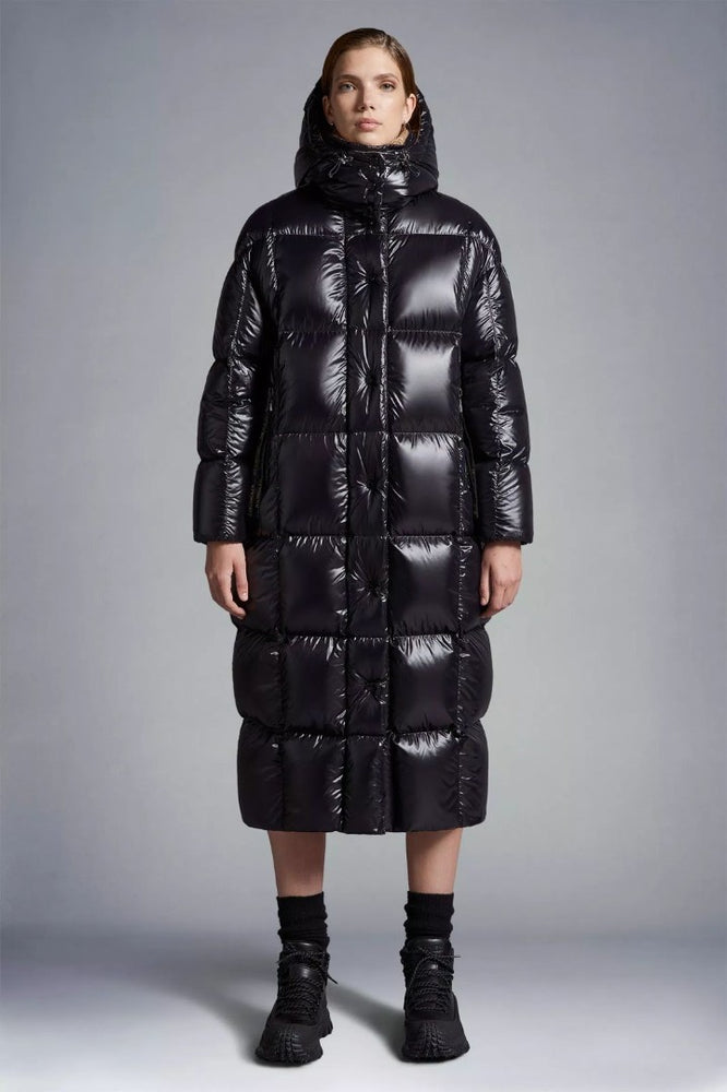Person wearing a long black puffer coat Moncler Cavettaz Hooded Long Down Jacket at Volonka store