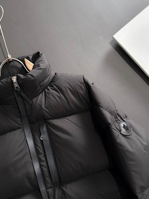 Black puffer jacket on a hanger against a gray wall. Moncler Men's Besbre Padded Jacket