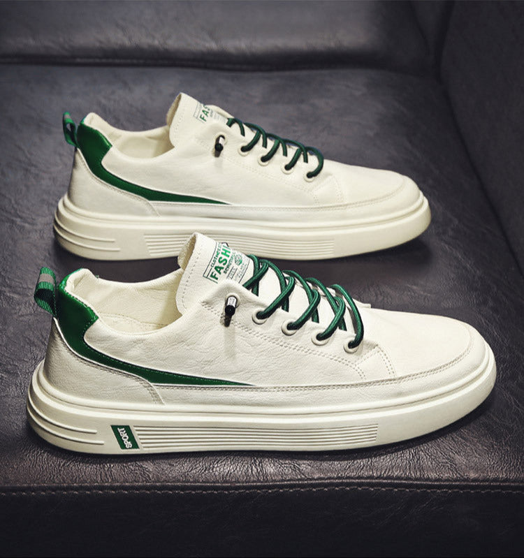 White sneakers with green accents on a dark surface
