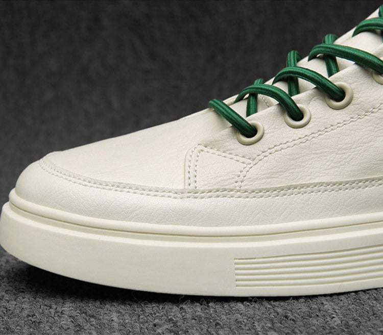 White sneaker with green laces on a dark background