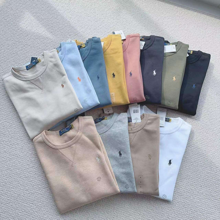 Stack of folded Polo Ralph Lauren sweatshirts in multiple colors including yellow, gray, blue, and pink