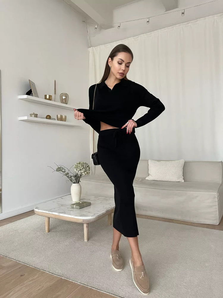 Woman in a black outfit standing in a modern living room. Chic Elegant Soft Knit Sweater with Skirt Set