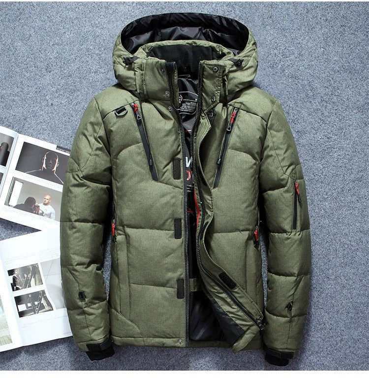 Green winter jacket with multiple zippers on a gray background