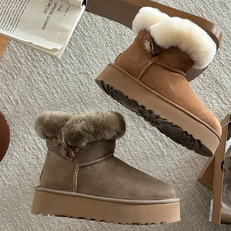 UGG Women's Winter Boots with Platform Sole at Volonka. Pair of brown suede boots with white fur lining on a textured surface.