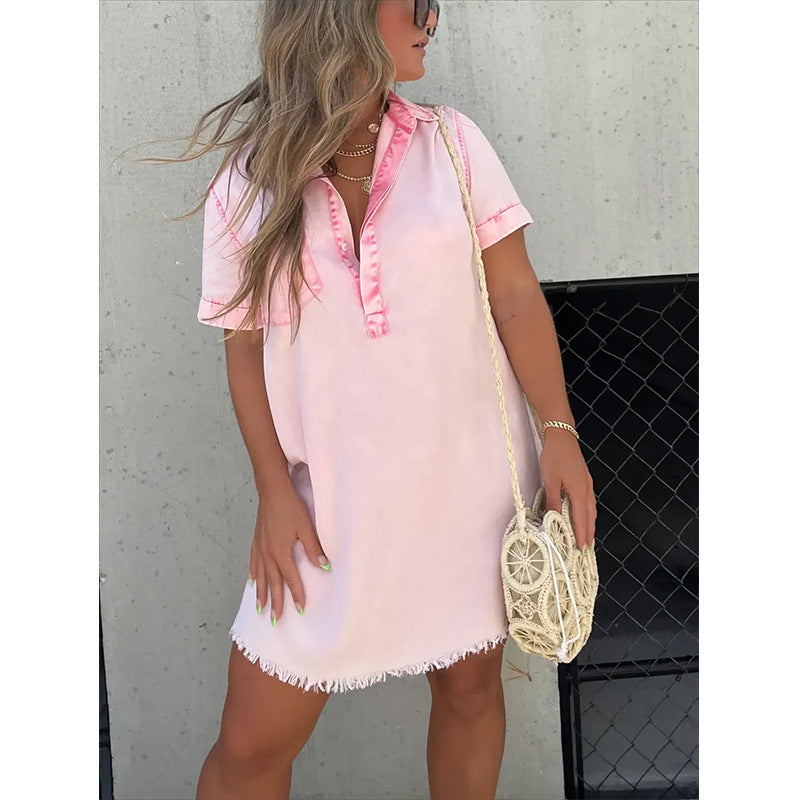 Woman wearing a pink and white denim dress with a neutral background