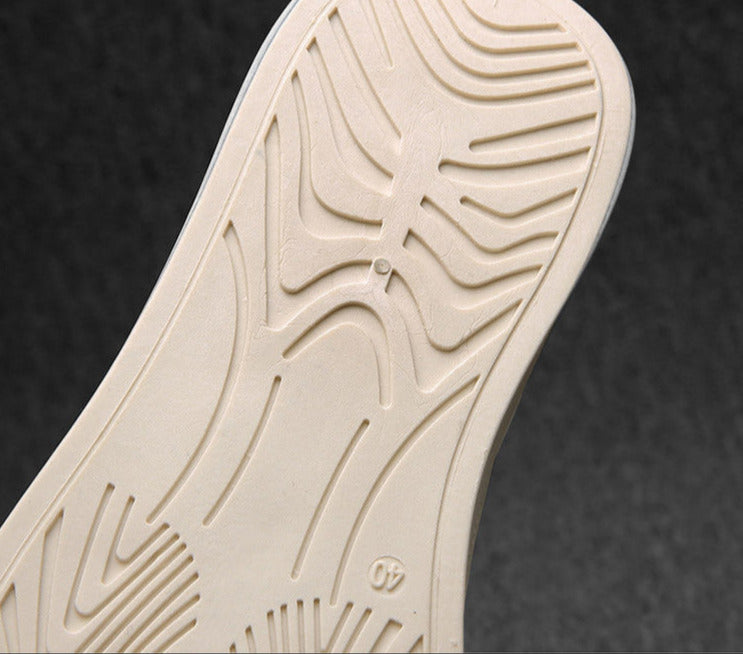 Close-up of a beige shoe sole with tread pattern on a dark background