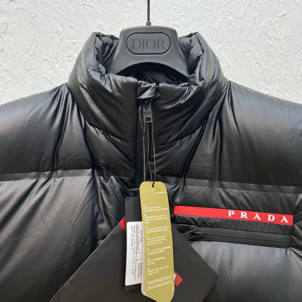 Black puffer jacket with Prada logo on a hanger. Prada Men's light Down Vest jacket