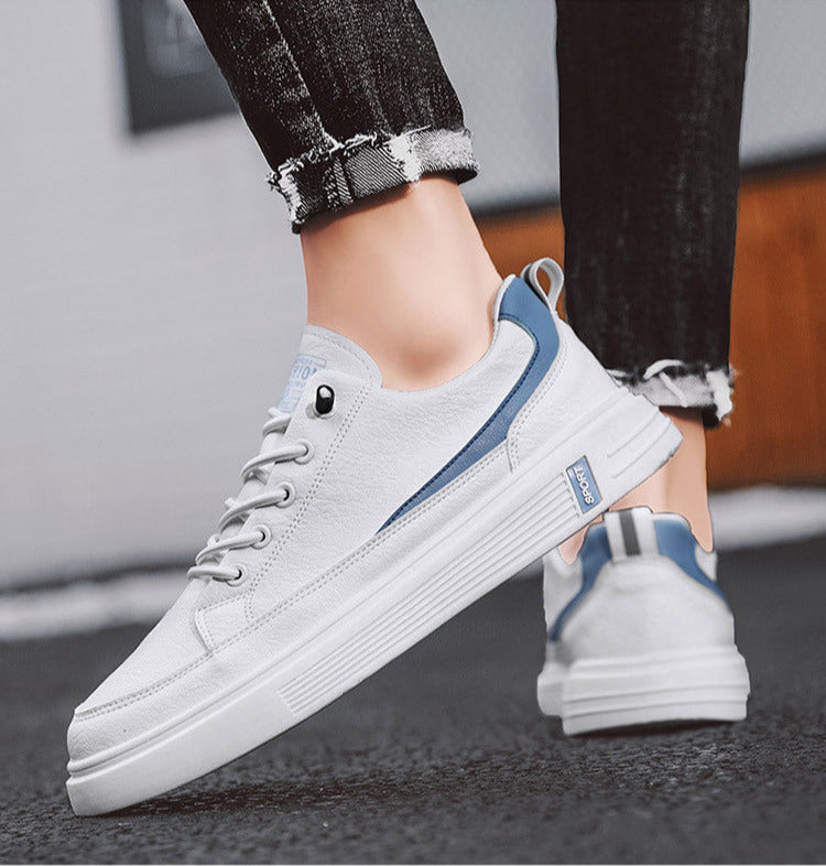 White sneakers with blue accents worn by a person on a blurred background
