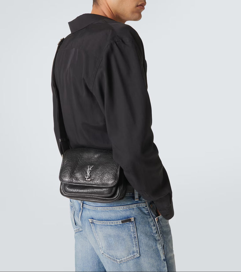 Man wearing a black leather bag with Saint Laurent Niki Small leather messenger bag at Volonka.