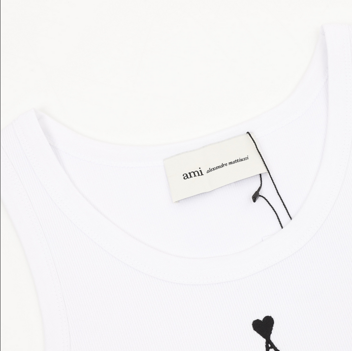 AMI Paris Heart Embroidered Tank displayed on a hanger, featuring a heart logo on a white tank top.