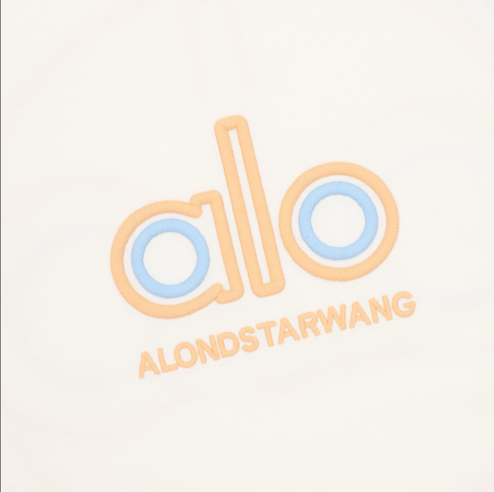 ALO Classic Minimal Short Sleeve Tshirt in white with logo on chest and red tag detail.