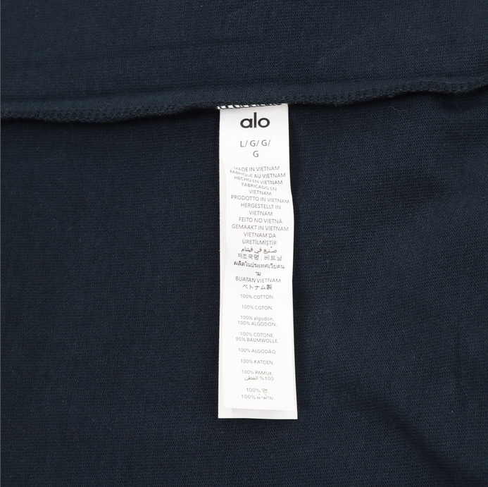 ALO Classic Minimal Short Sleeve Tshirt in navy blue with logo on chest and red tag detail.