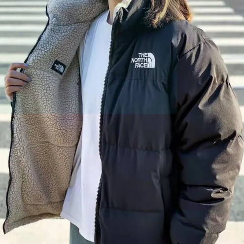 man wearing a black North Face jacket with a textured inner lining. The NorthFace Two Sided Lamb Coat Unisex jacket