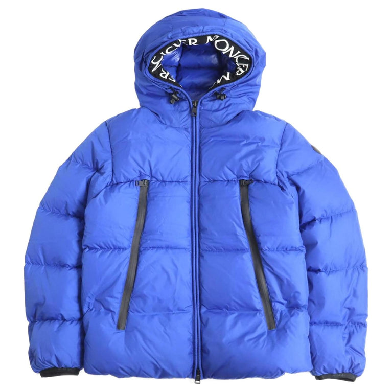 Blue puffer jacket with brand logo on hood against a white background. Moncler Montcla Short Down Jacket