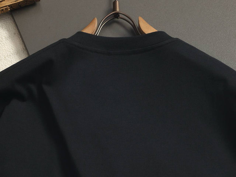 Burberry Cotton Label Oversize Tshirt displayed on a hanger with a classic black design and prominent logo.