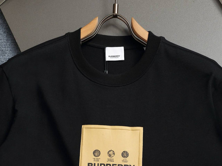 Burberry Cotton Label Oversize Tshirt displayed on a hanger with a classic black design and prominent logo.