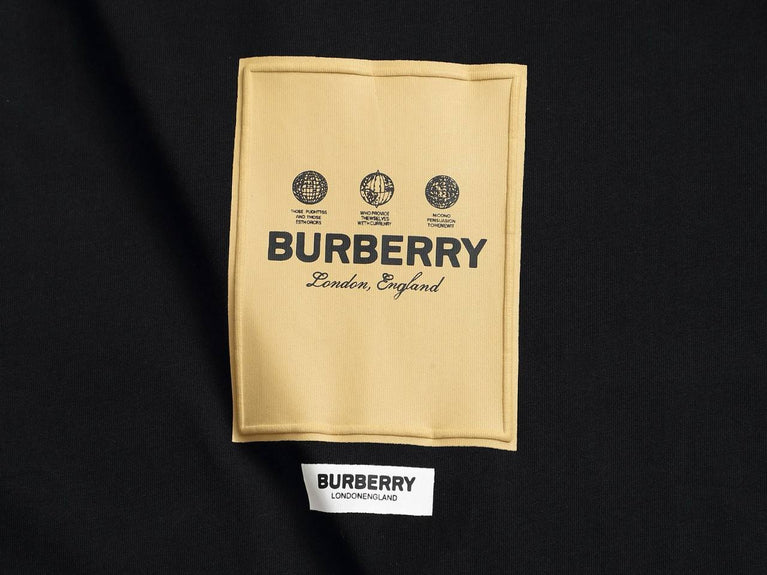 Burberry Cotton Label Oversize Tshirt displayed on a hanger with a classic black design and prominent logo.