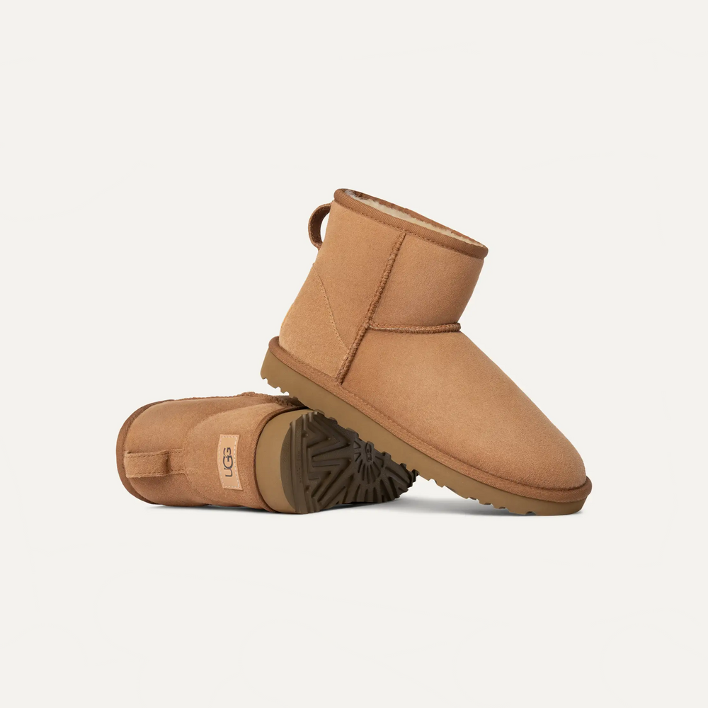 Pair of brown UGG boots on a light beige in volonka. UGG Women's Classic Cozy Sheepskin Mini II Boot