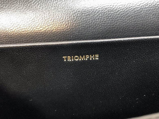 Black leather surface with 'TRIOMPHE' branding