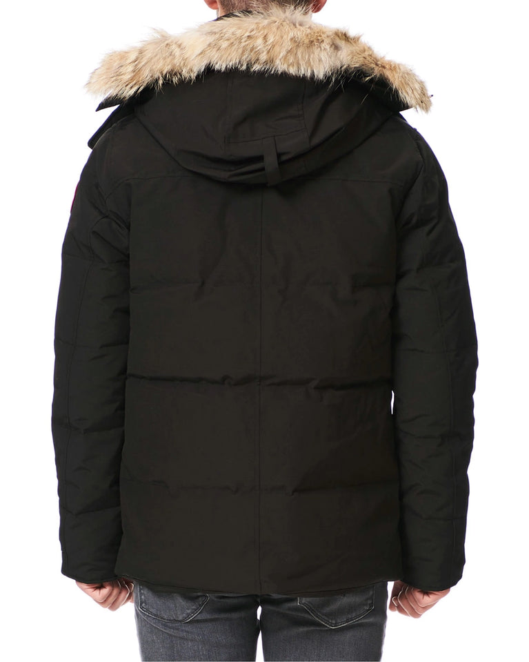 Black winter jacket with fur-lined hood on a white background. Canada Goose Wyndham Parka with Fur jacket