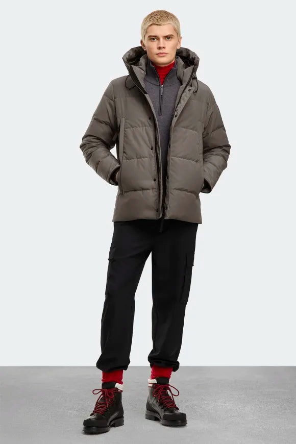 Man wearing Canada Goose Wyndham Parka Goose Men's Winter Jacket at Volonka. Gray puffer jacket with a hood.