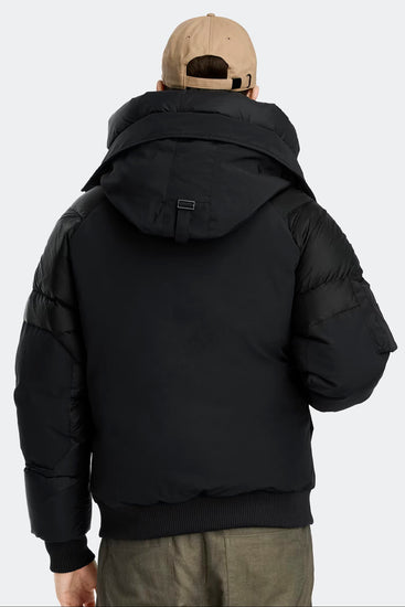 Man wearing a black puffer jacket and beige cap, Canada Goose Paradigm Chilliwack Bomber Unisex Down Jacket at Volonka store.