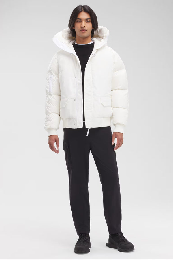 Man wearing a white puffer jacket with a hood, Canada Goose Paradigm Chilliwack Bomber Unisex Down Jacket at Volonka store.