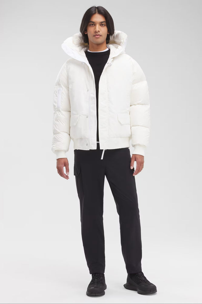 Man wearing a white puffer jacket with a hood, Canada Goose Paradigm Chilliwack Bomber Unisex Down Jacket at Volonka store.