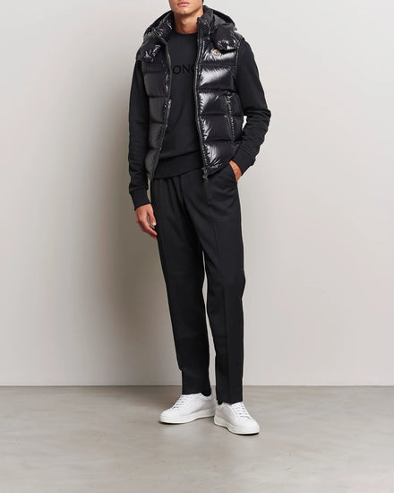Man wearing a black outfit with a shiny vest. Moncler unisex Bormes down vest jacket