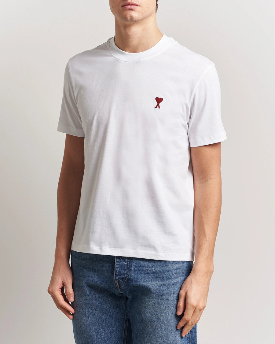 AMI Paris Heart Logo Men Tshirt featuring a white color and a red heart logo on the chest.