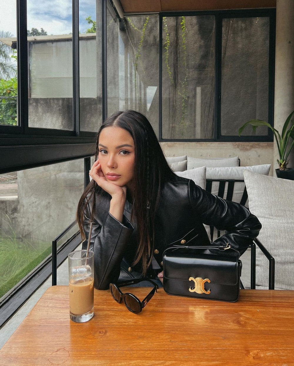 Woman in a black leather jacket with a Celine Triomphe Shoulder Bag at Volonka.