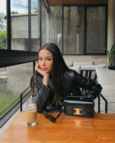 Woman in a black leather jacket with a Celine Triomphe Shoulder Bag at Volonka.