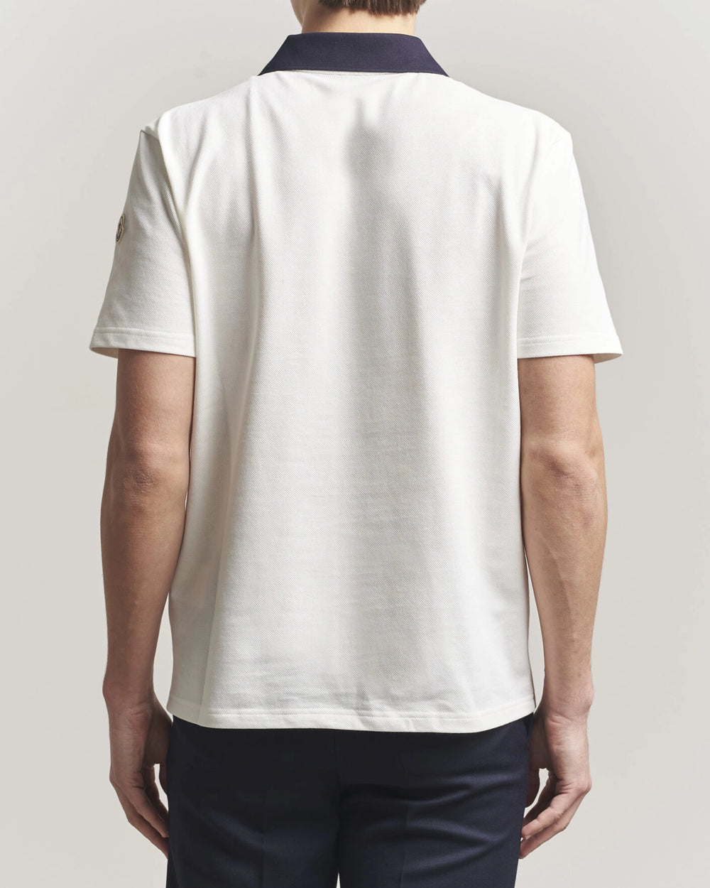 Moncler Men Signature Logo Polo displayed on a neutral background, featuring a classic collar and signature logo.