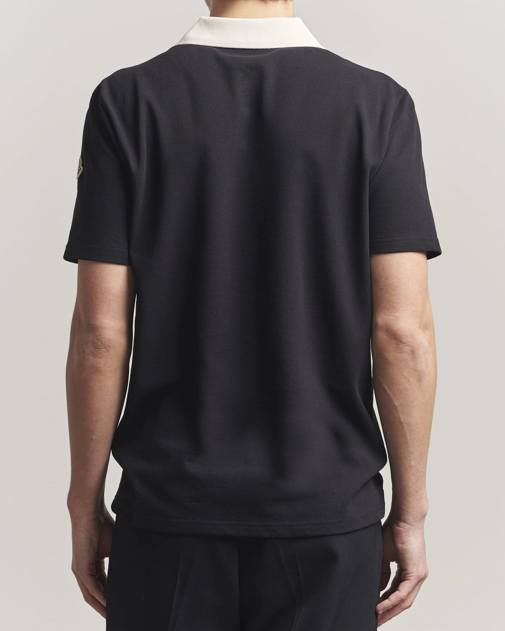 Moncler Men Signature Logo Polo displayed on a neutral background, featuring a classic collar and signature logo.