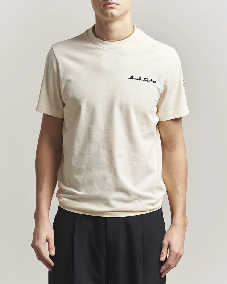 Moncler Men Signature Logo Tshirt displayed in Off white, featuring logo detail and contrasting neckline.