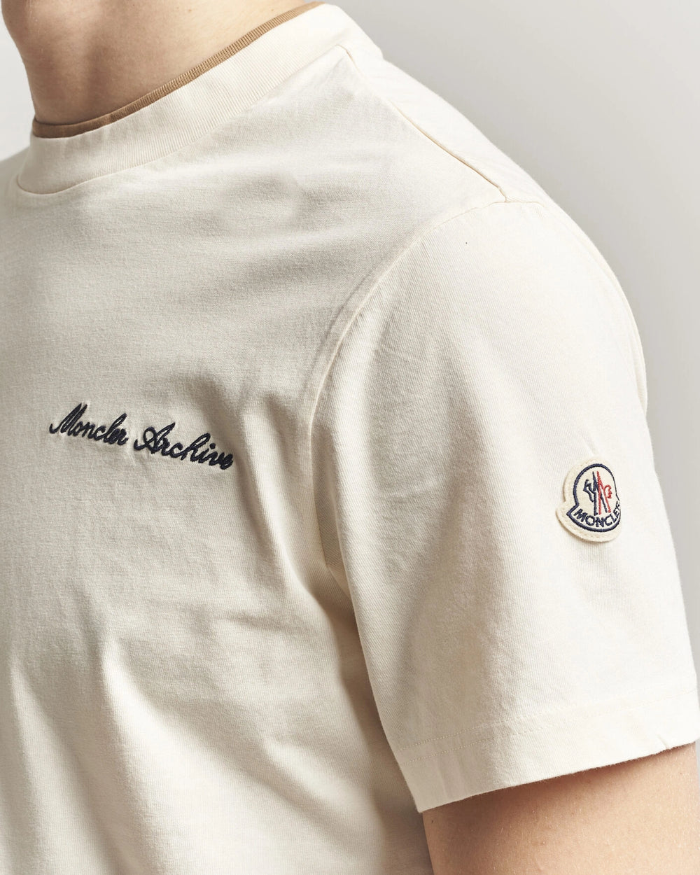 Moncler Men Signature Logo Tshirt displayed in Off white, featuring logo detail and contrasting neckline.