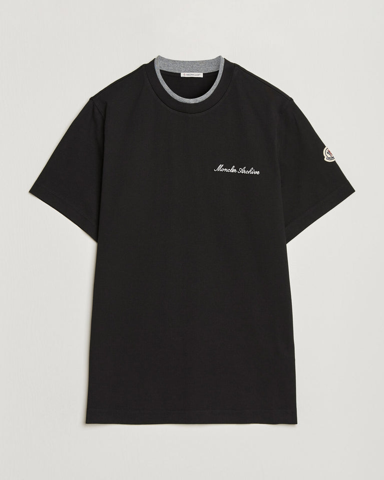 Moncler Men Signature Logo Tshirt displayed in black, featuring logo detail and contrasting neckline.