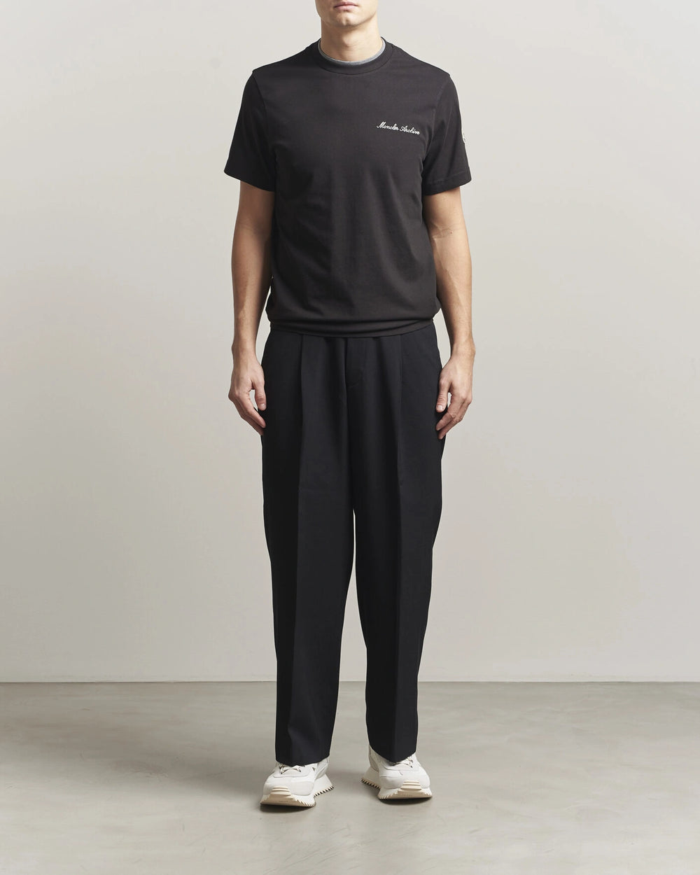 Moncler Men Signature Logo Tshirt displayed in black, featuring logo detail and contrasting neckline.