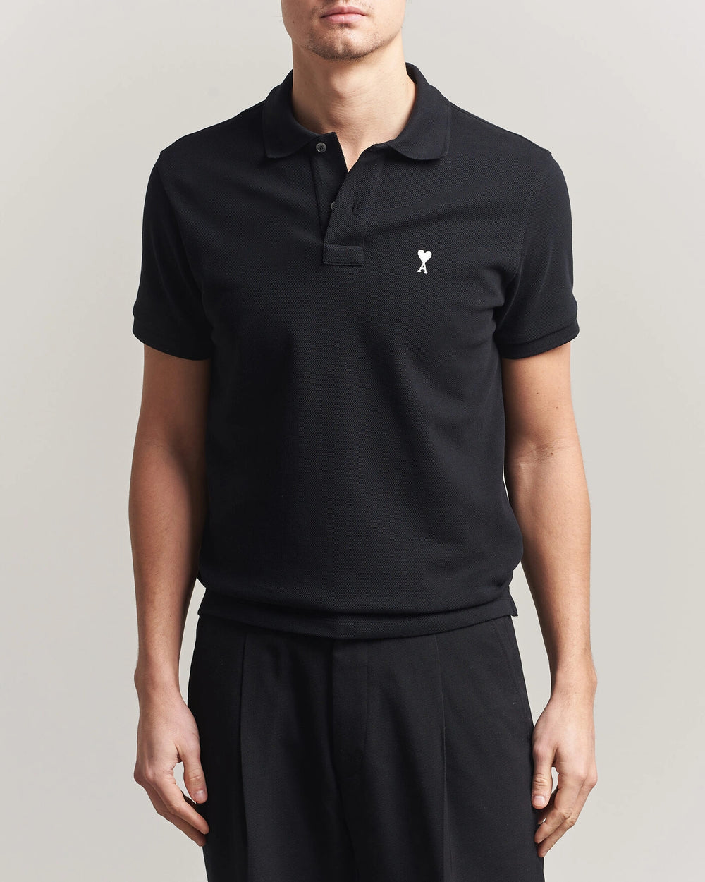AMI Paris Heart Logo Men Polo Shirt in black, featuring a heart logo, classic and modern style.