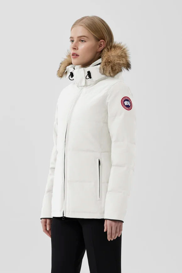 Woman wearing a white parka with a fur-lined hood. Canada Goose Chelsea Parka Women's Down Winter Jacket at Volonka store.