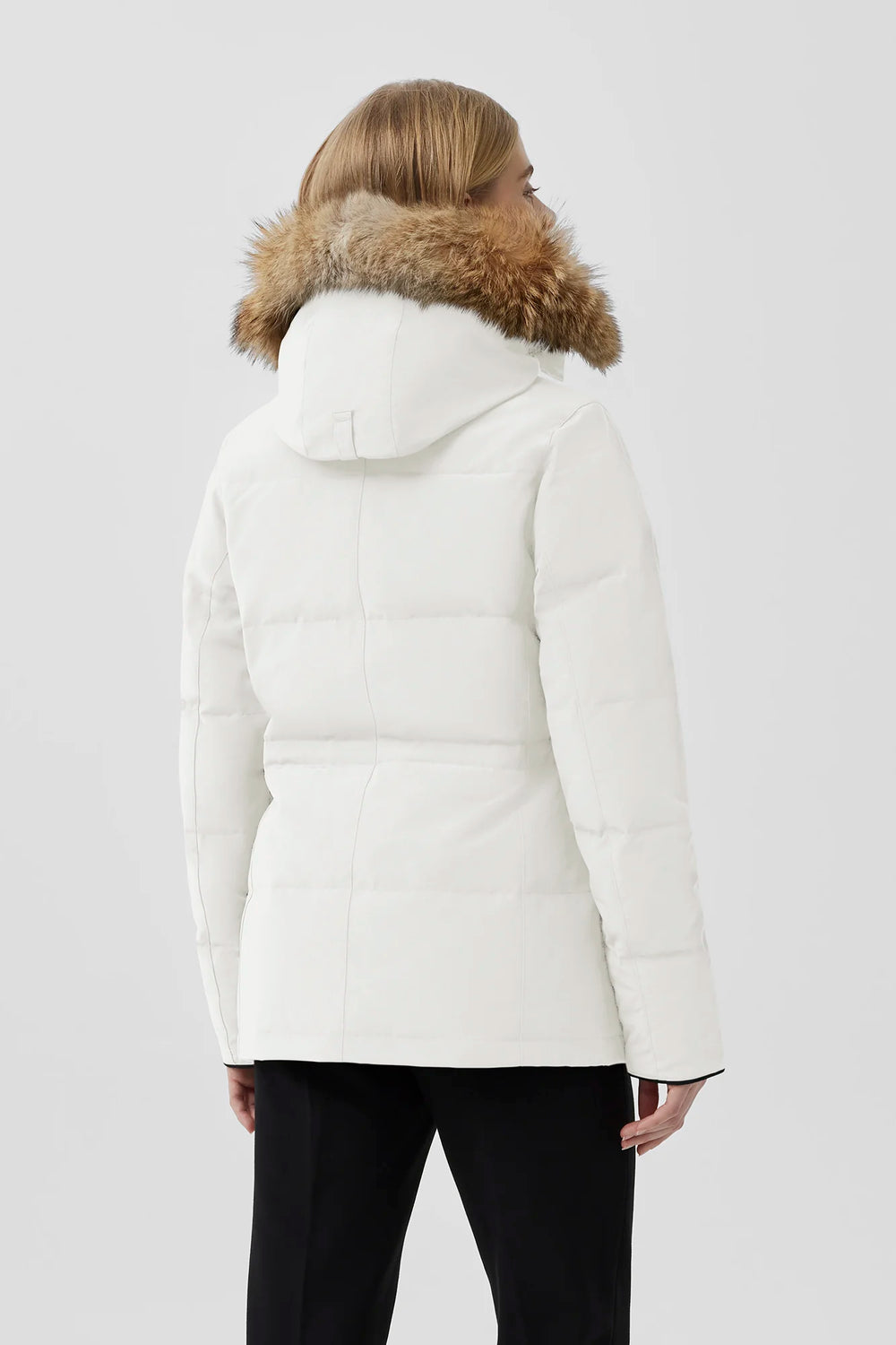 Woman wearing a white puffer jacket with fur hood, Canada Goose Chelsea Parka Women's Down Winter Jacket at Volonka store.