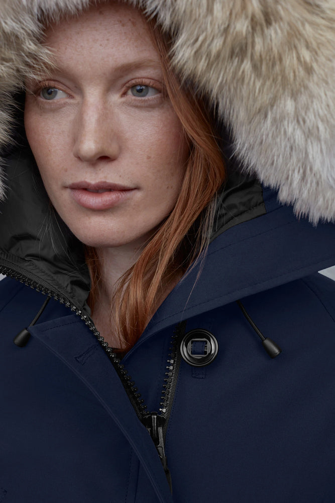 Person wearing a dark blue coat with a fur-lined hood. Canada Goose Chilliwack Bomber Women's Winter Hooded Jacket